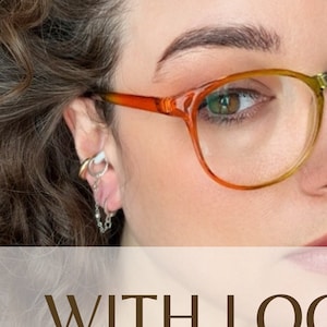 Könnte beinhalten: Eine Frau trägt eine Regenbogenbrille mit einem silbernen Kettenohrring. Der Text "WITH LOOPS" ist im Bild sichtbar.