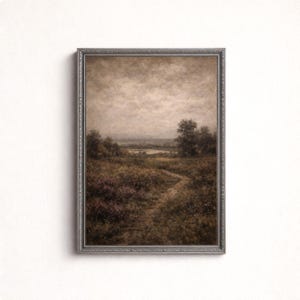 May include: A framed landscape print depicting a path through a field of wildflowers and trees. The artwork uses a muted palette of browns, greens, and purples, with a cloudy sky. The frame is silver.
