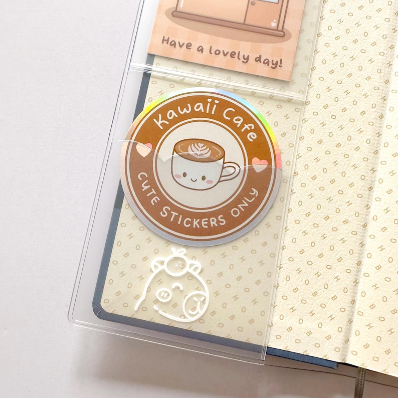 Op de afbeelding: Een holografische sticker met een schattig cartoon-koffiekopje en de tekst "Kawaii Cafe Cute Stickers Only".