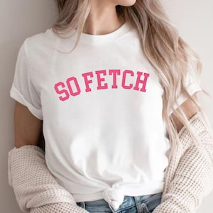 Op de afbeelding: Wit T-shirt met de tekst "SO FETCH" in roze letters.
