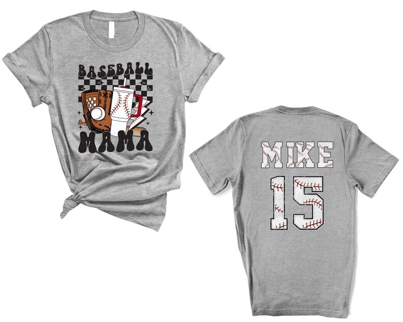 May include: A heather gray baseball t-shirt with the words "BASEBALL MAMA" and baseball-themed graphics on the front. The back of the shirt displays "MIKE" and the number "15" in a baseball stitch design.