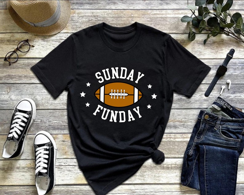 Pode incluir: Camiseta preta com um gr&aacute;fico branco de uma bola de futebol e o texto "SUNDAY FUNDAY".