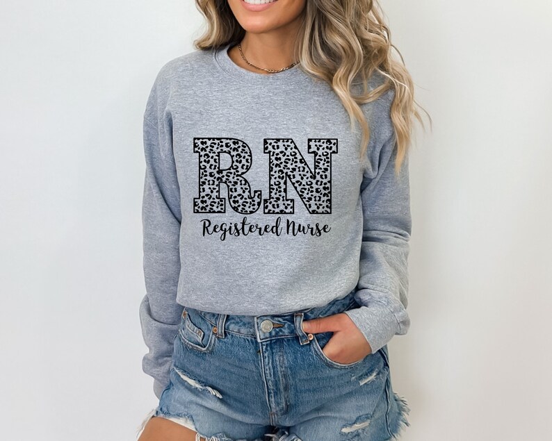 May include: A gray sweatshirt with a leopard print "RN" design and the text "Registered Nurse" below.
