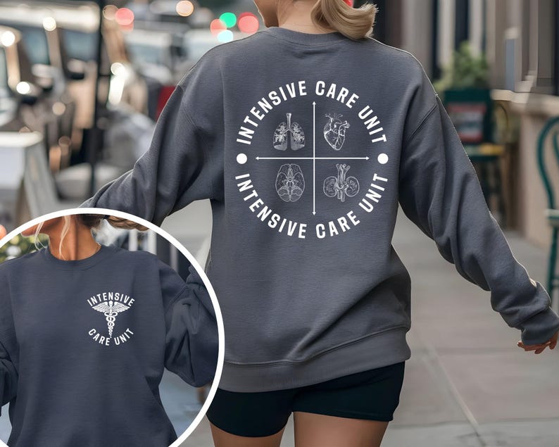 May include: A dark gray sweatshirt with the words "INTENSIVE CARE UNIT" in a circular design on the back. The design includes illustrations of lungs, a heart, a brain, and kidneys. A smaller image shows a similar sweatshirt with a medical symbol.
