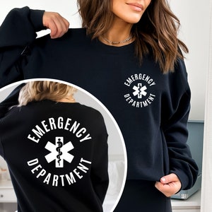 May include: Black sweatshirt with a white circle graphic on the front and back. The graphic features a medical symbol with a snake and the text "Emergency Department".