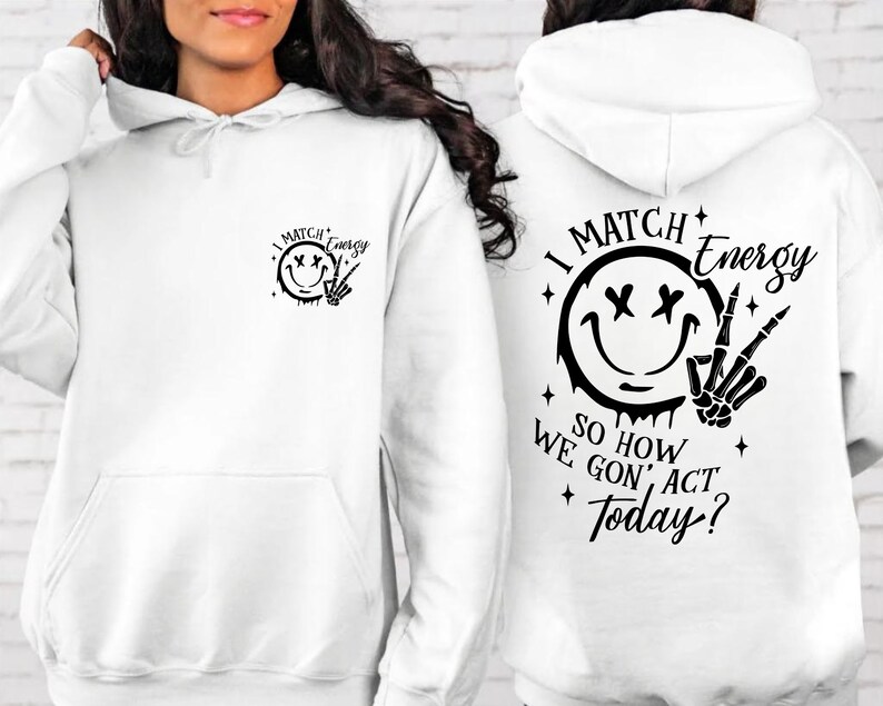 Puede incluir: Sudadera con capucha blanca con una cara sonriente negra y un gr&aacute;fico de mano de esqueleto. El texto "I Match Energy So How We Gon' Act Today?" est&aacute; impreso en la sudadera.