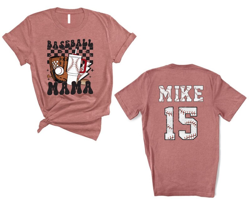 May include: A dusty rose baseball t-shirt with a graphic on the front that says "Baseball Mama". The graphic includes a baseball glove, a baseball, and a drink. The back of the shirt says "MIKE 15".
