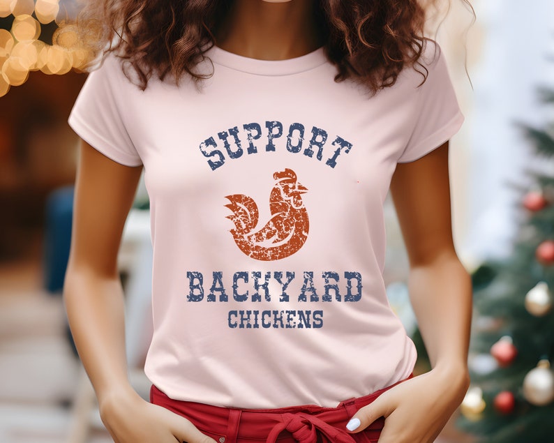 May include: A pink t-shirt with a distressed blue and white graphic that says "Support Backyard Chickens" with a distressed orange rooster graphic.