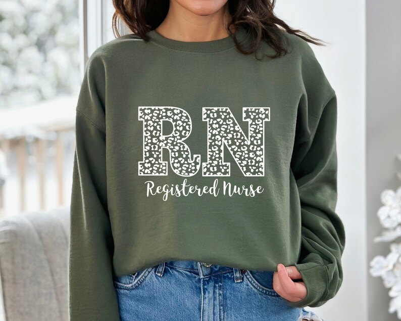 May include: A green sweatshirt with a white leopard print "RN Registered Nurse" design.