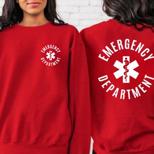 May include: Red sweatshirt with a white graphic of a medical symbol and the text "Emergency Department".