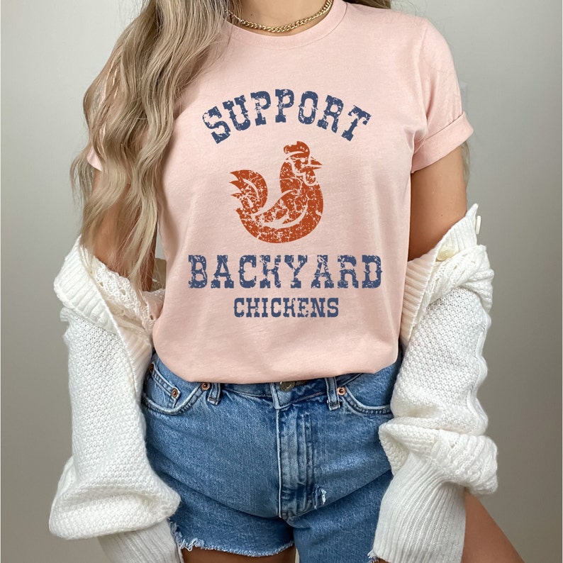 May include: A pink t-shirt with a distressed graphic of a rooster and the text "Support Backyard Chickens".