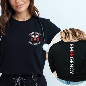 Puede incluir: Camiseta negra con la inscripci&oacute;n "Emergency Department" y un s&iacute;mbolo m&eacute;dico en la parte delantera. La parte trasera de la camiseta tiene la palabra "EMERGENCY" en blanco y rojo, impresa verticalmente.
