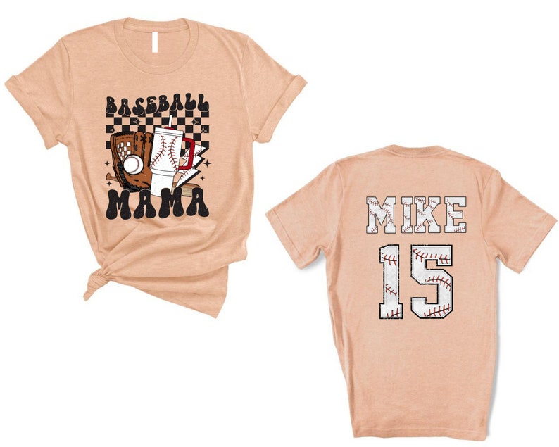 May include: Peach-colored baseball t-shirt. The front features a baseball glove, ball, and the words "BASEBALL MAMA". The back displays "MIKE 15" in a baseball-themed design.