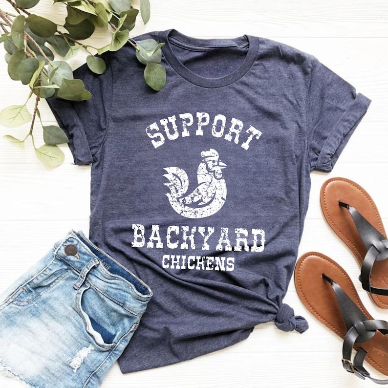 May include: A navy blue t-shirt with a white distressed graphic of a rooster and the text "Support Backyard Chickens".