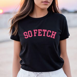 Op de afbeelding: Zwart gecropped T-shirt met een roze "SO FETCH" print.