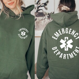 May include: A green hooded sweatshirt with a white graphic of a medical symbol and the text "Emergency Department".