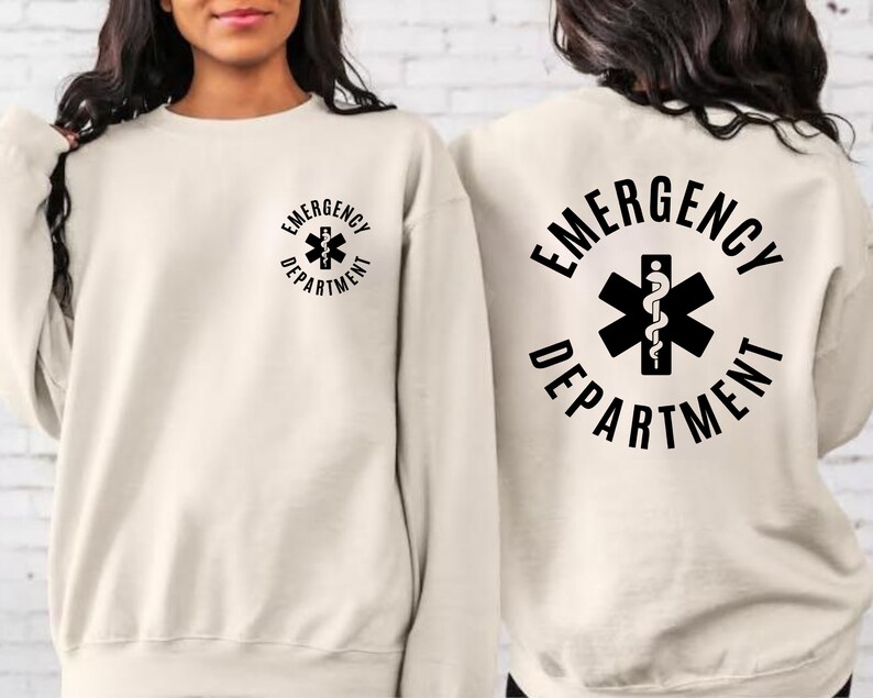 May include: A cream colored sweatshirt with the text "EMERGENCY DEPARTMENT" and a medical symbol on the back. The same text and symbol are on the front of the sweatshirt in a smaller size.