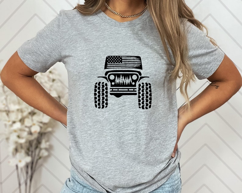 May include: A gray t-shirt with a black graphic of a Jeep with an American flag on the hood.