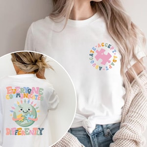 May include: White t-shirt with a colorful graphic on the back that says "Everyone Communicates Differently" and a colorful graphic on the front that says "Advocate Accept Adapt".