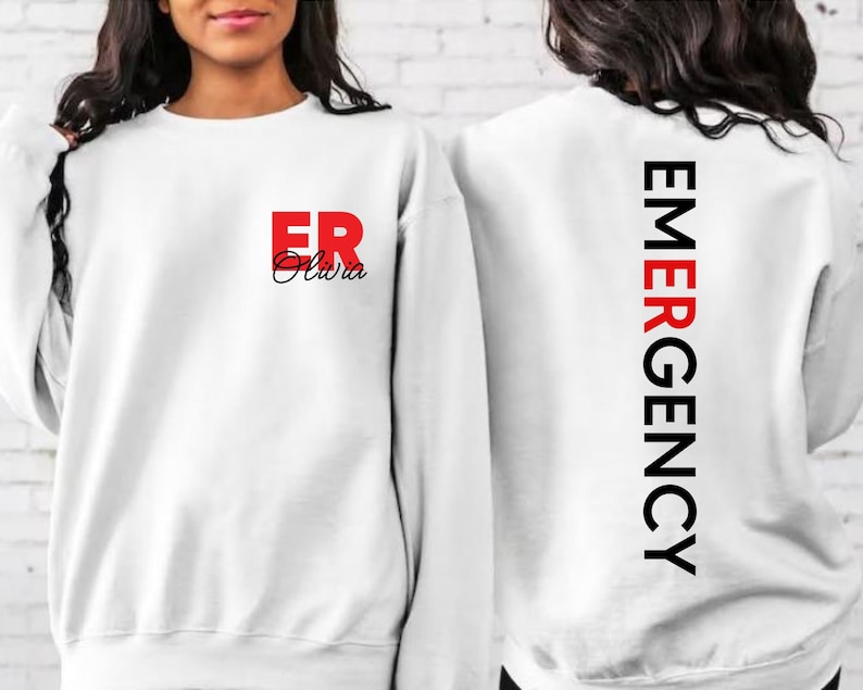 May include: White sweatshirt with the text "ER Olivia" in red and black on the front and "EMERGENCY" in black on the back.