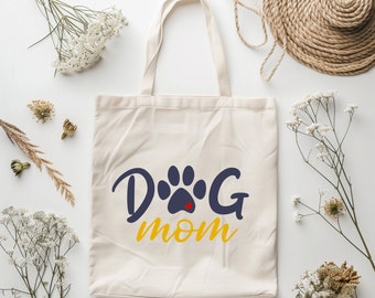 May include: A white canvas tote bag with a blue paw print and the text "Dog Mom" in yellow.