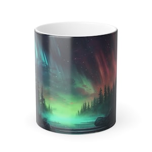 May include: A white ceramic mug with a colorful aurora borealis scene printed on it. The scene features a dark forest with a lake in the foreground and a vibrant green, blue, and red aurora in the sky.