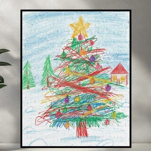 May include: A framed Christmas-themed puzzle featuring a child's drawing of a Christmas tree. The tree is decorated with colorful ornaments and a star on top. The background includes a house, trees, and a snowy landscape. The artwork is framed in a black border.