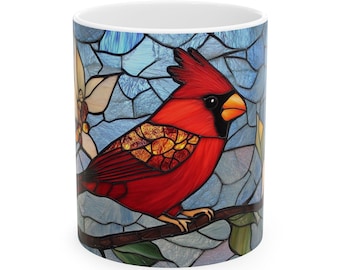 May include: A white ceramic mug with a stained glass design of a red cardinal perched on a branch. The background is a blue and white mosaic pattern.