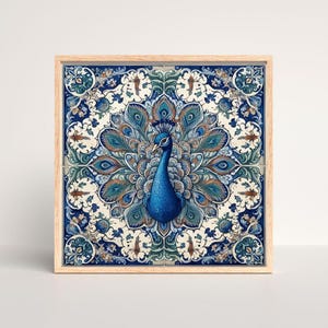 Peut inclure: Une décoration murale carrée présentant une illustration centrale de paon bleu entourée de motifs floraux et de plumes symétriques et complexes dans des tons bleu profond, sarcelle et crème, le tout dans un cadre en bois clair.