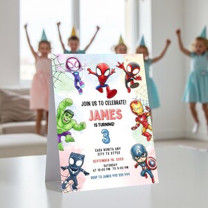 May include: A birthday party invitation featuring superhero characters. The invitation includes the text "JOIN US TO CELEBRATE! JAMES IS TURNING 3" with event details. The design includes illustrations of Spider-Man, Hulk, and Captain America.