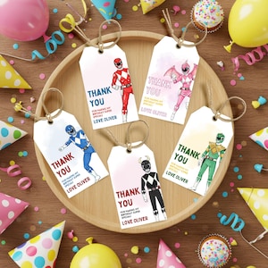 May include: Set of five gift tags with Power Rangers illustrations. Each tag has a string for hanging and features the text "THANK YOU" and "FOR MAKING MY BIRTHDAY SUPER SPECIAL! LOVE OLIVER". Party decorations surround the tags.