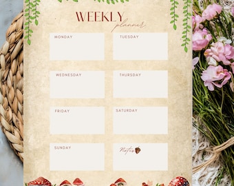 Può includere: Un'agenda settimanale dal design vintage. Lo sfondo color crema presenta le parole "WEEKLY planner" in bordeaux. Include caselle per ogni giorno della settimana, con funghi decorativi e una fata in basso. Viti e foglie verdi adornano la parte superiore.