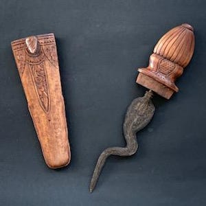 Peut inclure: Un fourreau en bois et une poignée en bois sculpté avec une lame incurvée en métal foncé. La lame est en forme de serpent.