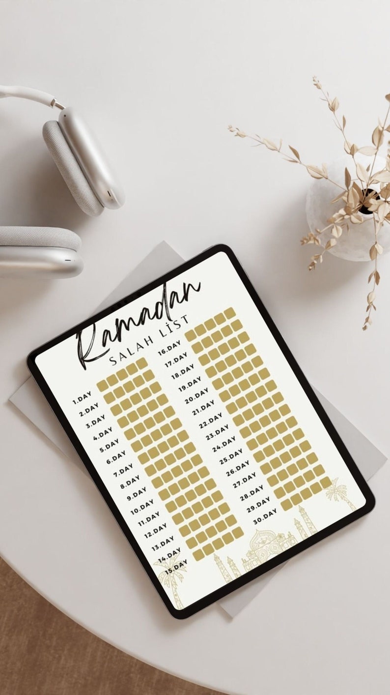 May include: A digital tablet with a white background and black text. The text reads "Ramadan Salah List" and lists the days of Ramadan from 1 to 30. Each day has a corresponding gold square to check off.