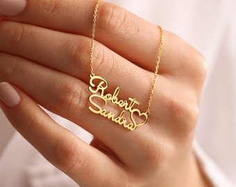 May include: Gold necklace with the names "Robert" and "Sandra" intertwined with a heart symbol.