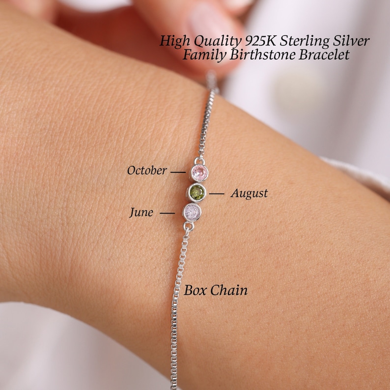 Puede incluir: Un brazalete de cadena de plata con tres dijes de piedras de nacimiento. Los dijes son rosa, verde y transparente. El brazalete tiene un estilo de cadena de caja y est&aacute; etiquetado como "junio", "octubre" y "agosto".