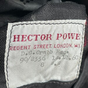 May include: A white label with black stitching and red text that reads "HECTOR POWE REGENT STREET LONDON W.1.  D.G.C. 90/2336 12.60"