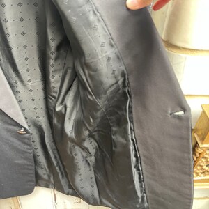 May include: Black blazer with a patterned lining. The blazer has a single button closure and a pocket on the left side.