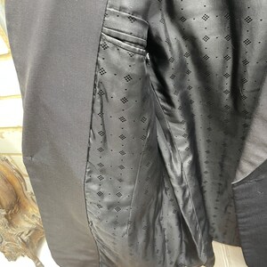 May include: Black blazer with a black patterned lining. The lining has a diamond pattern.