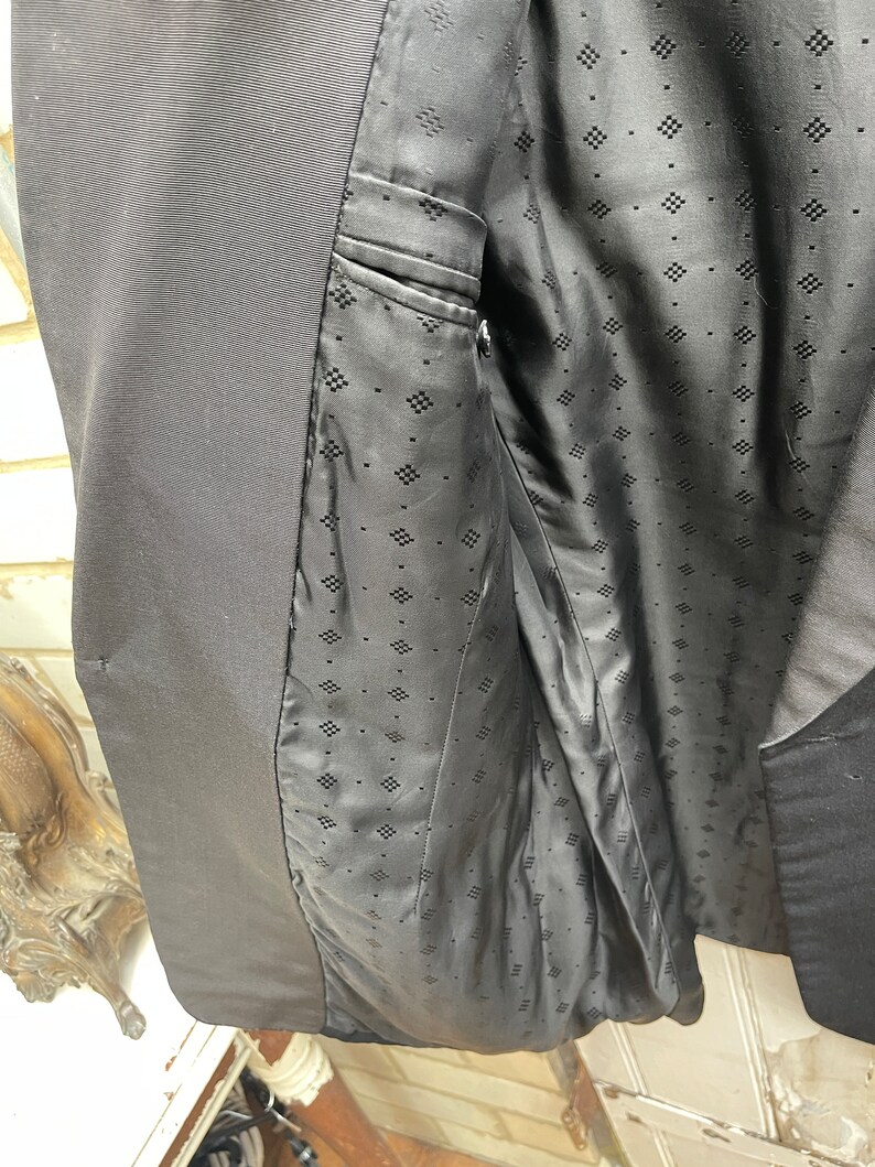 May include: Black blazer with a black patterned lining. The lining has a diamond pattern.