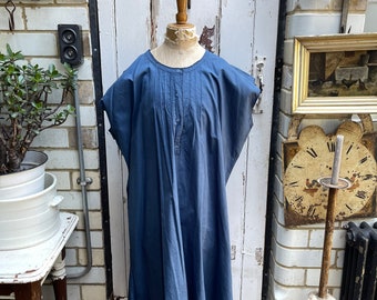 May include: A blue cotton dress with a round neckline and short sleeves. The dress has a button closure at the front and a gathered detail at the neckline.