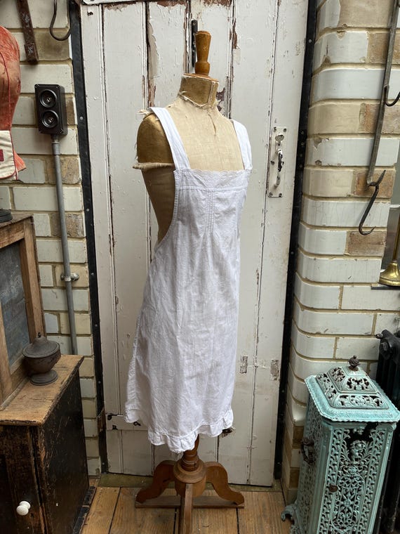 レースの縁取りが施されたアンティークホワイトコットンのピナフォア