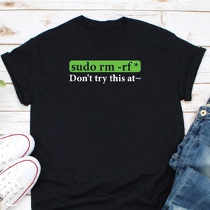 May include: Black t-shirt with a green box that says "sudo rm -rf*" and the text "Don't try this at~" in white.