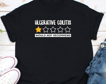 Op de afbeelding: Zwart T-shirt met witte tekst die "Ulceratieve Colitis" luidt en een één-sterrenbeoordeling met de tekst "Niet aan te bevelen".