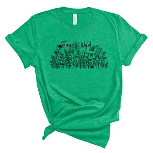 May include: Green t-shirt with a black graphic of flowers and the text "Stay Wild".