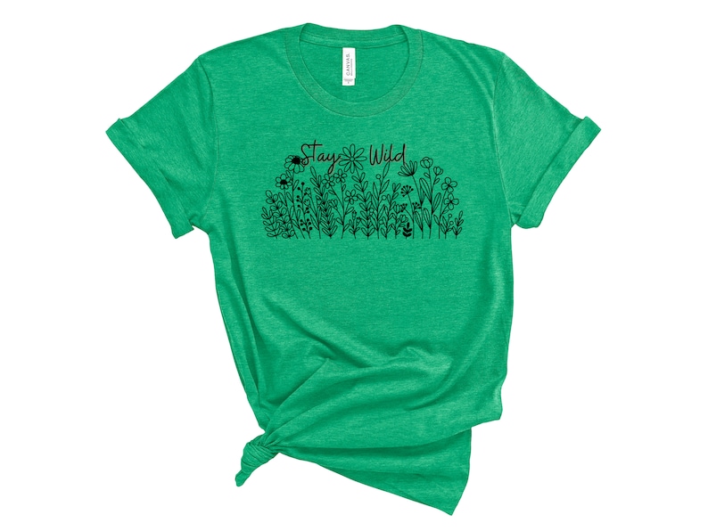 May include: Green t-shirt with a black graphic of flowers and the text "Stay Wild".