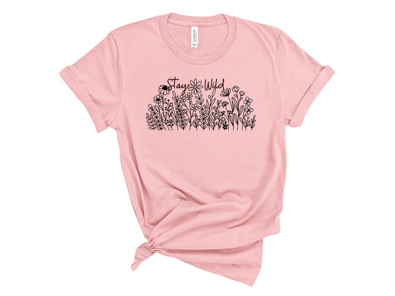 May include: A pink t-shirt with a black graphic of flowers and the text "Stay Wild".