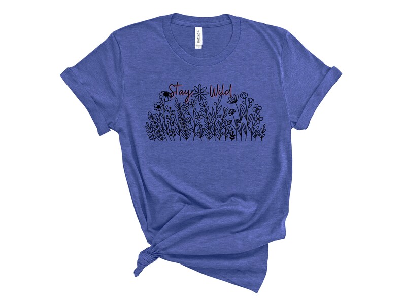May include: A blue t-shirt with a black and white floral design and the text "Stay Wild" in red.