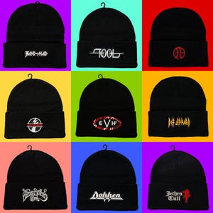 May include: Nine black beanies with different band logos embroidered on the front. The logos include "BAND-MAID", "TOOL", "CFD", "AC/DC", "EVH", "Def Leppard", "Allman Brothers Band", "Dokken", and "Jethro Tull". Each beanie has a small loop at the top.