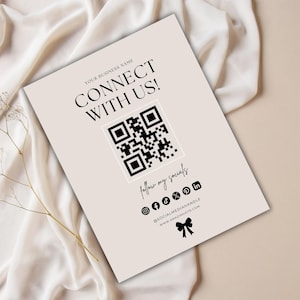 Może przedstawiać: Beżowa karta z napisem "CONNECT WITH US!" i kodem QR. Poniżej znajdują się ikony mediów społecznościowych i tekst "follow my socials". Karta zawiera również adres strony internetowej i grafikę kokardy.